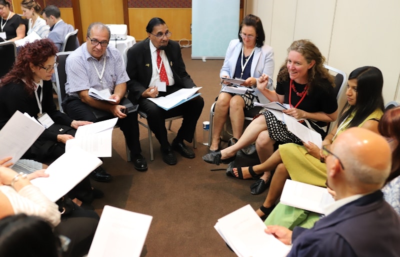 a circle of people studying the materials