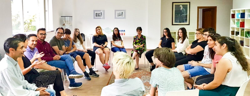 A group of people in a circle engaged in a conversation