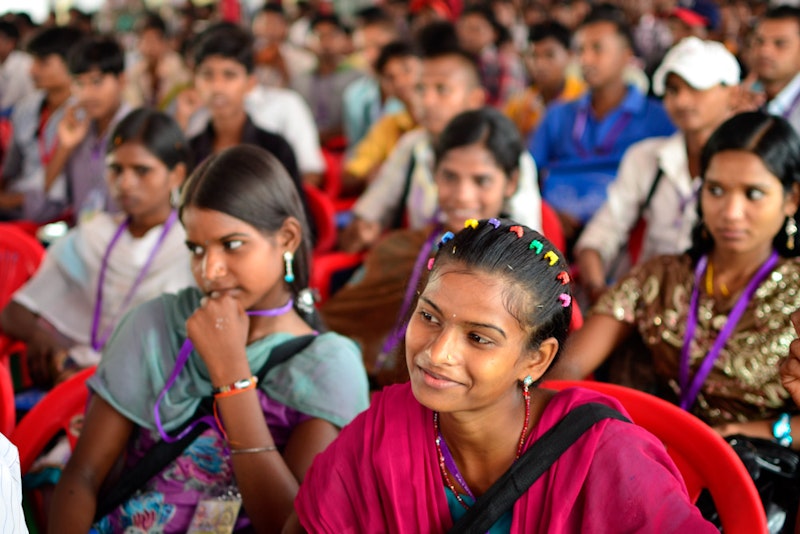 Large group of youth watching something attentively.